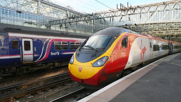 A FirstGroup service passing a Virgin Pendolino train in Glasgow Central Station