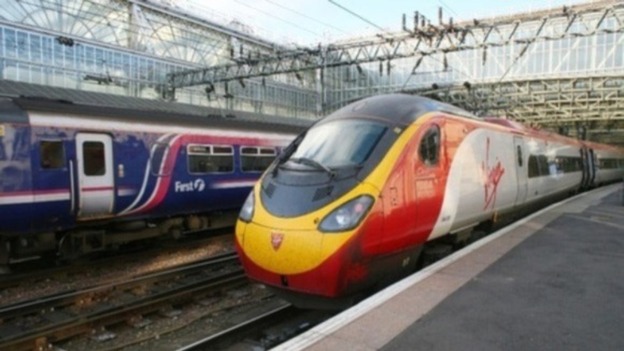 A Virgin Train at a platform alongside a FirstGroup carriage