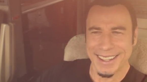 Travolta piloting a jet to meet Newton-John