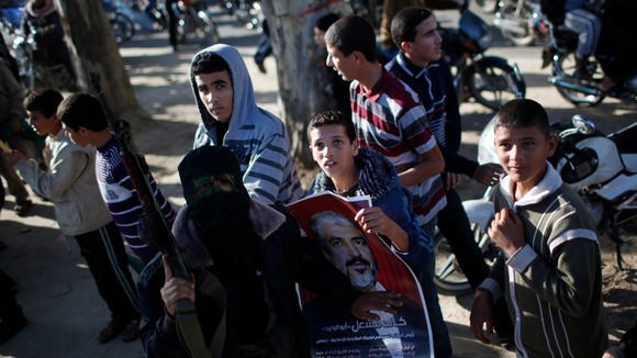 Boys surround an al-Qassam fighter in the southern Gaza Strip