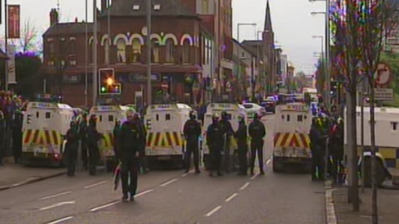 Police in riot gear line the streets of Belfast during the flag protest.