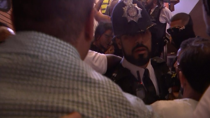 Police officers tried to prevent the crowd from getting up the stairs