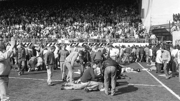 Fans on the pitch receive attention after severe crushing at Hillsborough during a Liverpool and Nottingham Forest match in 1989.