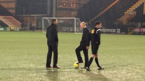Officials inspect the pitch