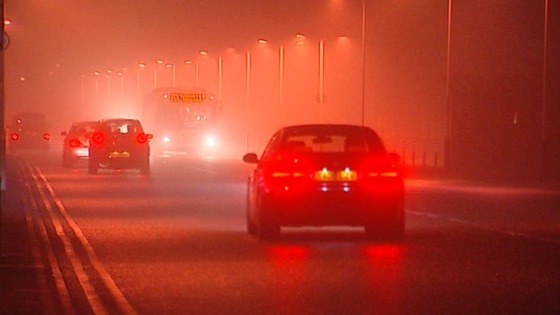 Cars and buses make their way through the fog around Heathrow Airport