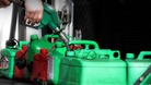 A man uses petrol pumps to fill petrol cans