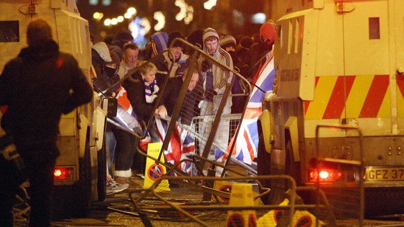 Loyalist protestors carrying Union flags clash with police outside the City Hall in Belfast