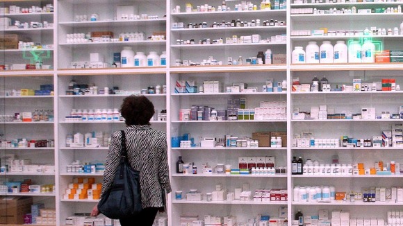 A woman looks at the gallery-sized installation 'Pharmacy'.