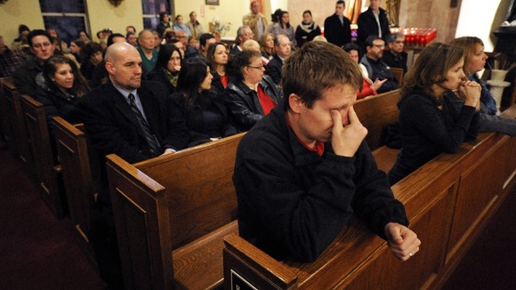 Mourners gather inside the St. Rose of Lima Roman Catholic Church