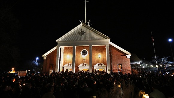 People stand outside a vigil at the Saint Rose of Lima church in Newtown, Connecticut