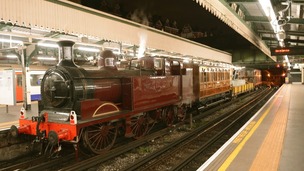 Steam train on London Underground tracks.