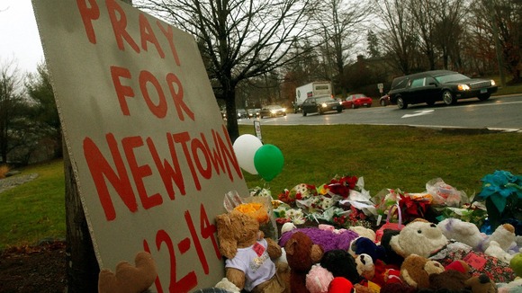 A funeral procession passed tributes left at a makeshift memorial in Newton, Connecticut