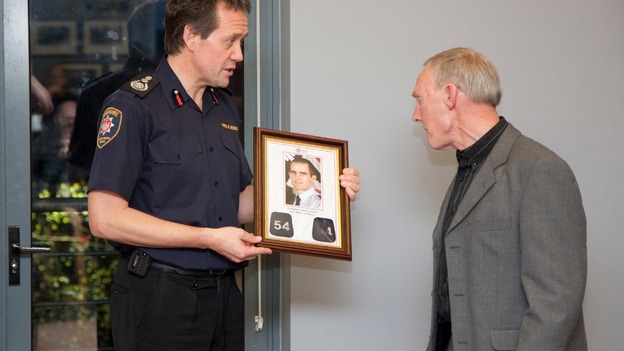 Chief Officer John Bonney presents James Shears's station number lapels to James's father Ed