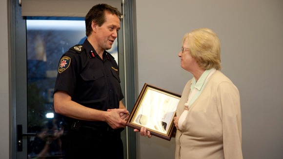 Chief Officer John Bonney presents Alan Bannon's station number lapels to Alan's mother Margaret