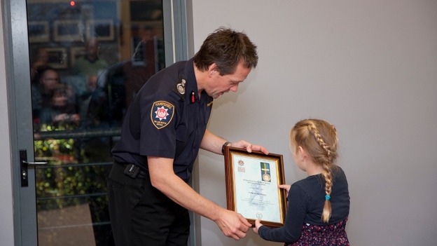 Chief Officer John Bonney presents Alan Bannon's Meritorious Medal for Gallantry to Alan's daughter Abi