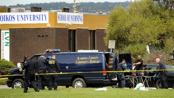 Sheriff's deputies remove a body from outside Oikos University in Oakland