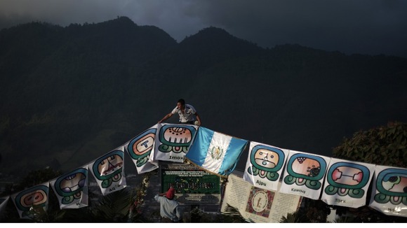 Man arranges pre-Hispanic symbols and Guatemalan flag ahead of a special ceremony
