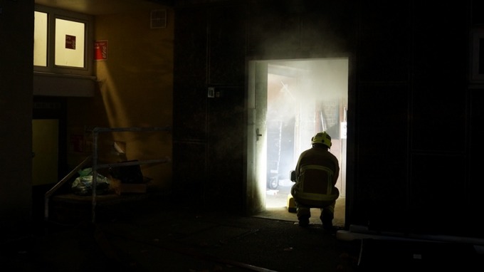 Although smoke was seen coming out of the top of the building, the fire actually in a ground floor rubbish bin room.