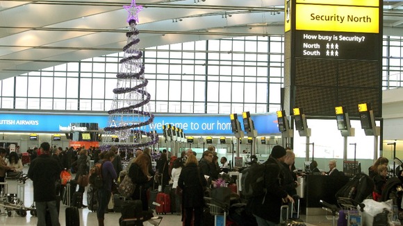 Passengers around the Christmas tree at Terminal 5 of Heathrow Airport as they travel home for Christmas.
