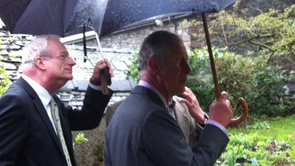 Prince Charles holding umbrella