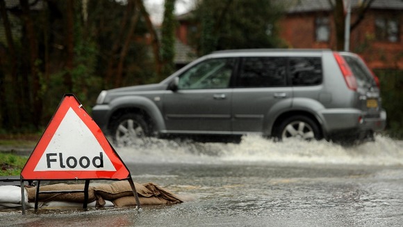 A vehicle makes its way through flood water on Calmore Road in Totton, Hampshire.