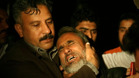 A man is comforted by his relative as he mourns his brother who was killed in a bomb blast in the Qissa Khawani Bazaar.