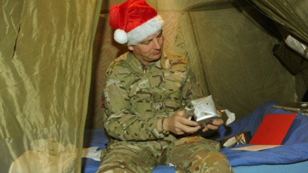 Warrant Officer Class 2, Craig Lawson, opens Christmas presents in his tent