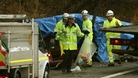 A policeman with a bag of items removed from the crashed car at the scene on the M6 northbound carriageway between junctions 14 and 15.