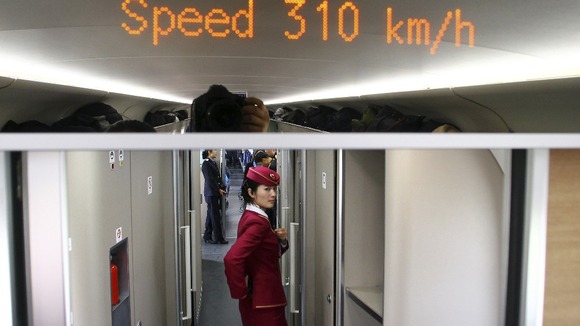 An attendant stands inside a high-speed train during a test trip from Beijing