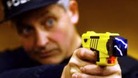 Police officer firing a taser gun