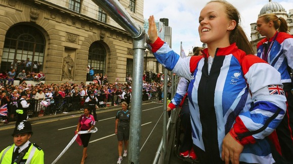 Swimming double gold and bronze medallist Ellie Simmonds waves to the crowd as she takes part in the London 2012 Victory Parade.