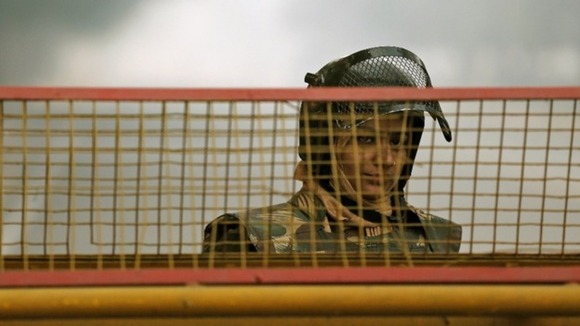 A policewoman stands guard at a barricade to stop protesters, near India Gate in New Delhi