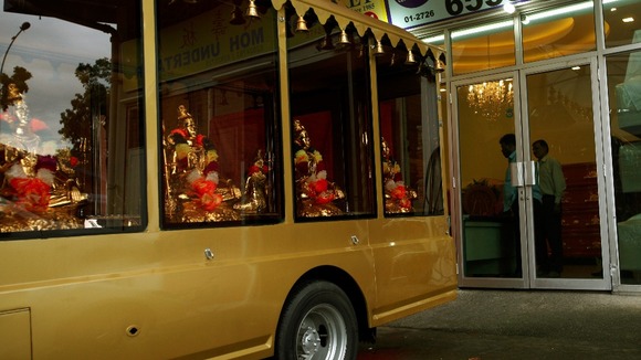 The hearse that will transport the victim's body is parked outside the Singapore funeral parlour