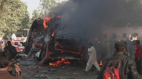 A public bus on fire after the explosion outside the railway station in Karachi