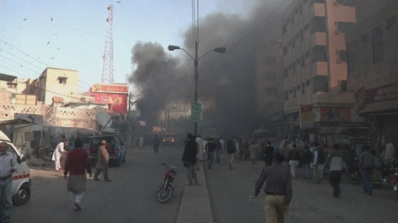 People gather to see what has happened as smoke rises from the blast