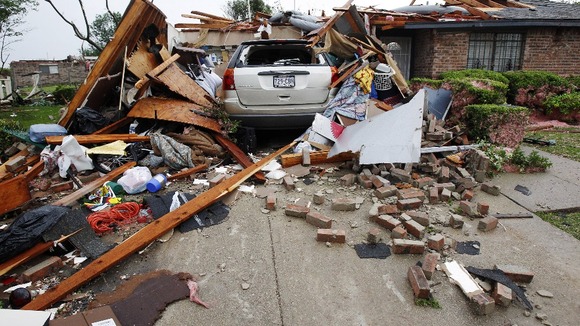 A vehicle rests in the driveway of a home destroyed by a series of tornadoes ripping through the Dallas suburb of Lancaster