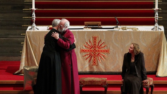 The Archbishop of Canterbury Dr. Rowan Williams 62, (centre) embraces the Very Revd Dr. Robert Willis, Dean of Canterbury Cathedral.