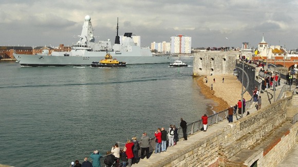 Crowds watch HMS Dauntless begin her maiden deployment.