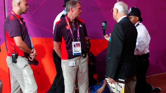 Olympic official with bottle thrown onto track