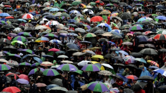 Wimbledon fans sheltered from the rain on Murray Mount in June.