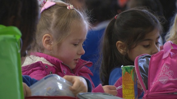 Two small girls eating their lunch at school