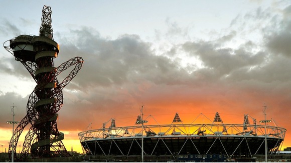 The sun sets behind the Olympic Stadium and Orbit tower at the Olympic Park in Stratford in east London