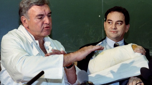 French surgeon Professor Jean-Michel Dubernard makes a point near Clint Hallam's bandaged forearm