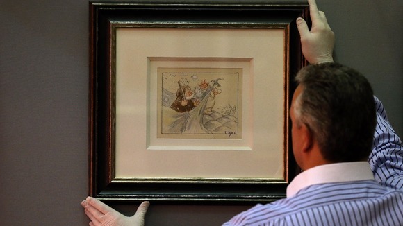 David Smith of Neptune Fine Art in Derbyshire, hangs an original artwork from Walt Disney's 'Snow White and the Seven Dwarfs' movie