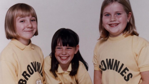 Brownies model their uniforms in 1990