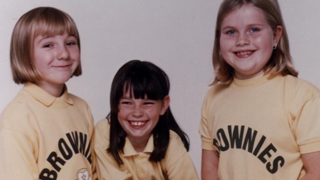 Brownies model their uniforms in 1990
