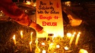 A participant lights a candle next to a sign during a vigil for the Indian rape victim