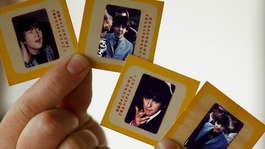Auctioneer Paul Fairweather holds four colour transparencies of The Beatles taken during their first tour of the USA in 1964.
