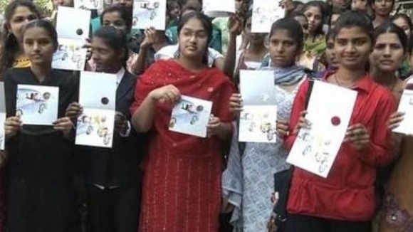 A group of students pose with a women's safety card.