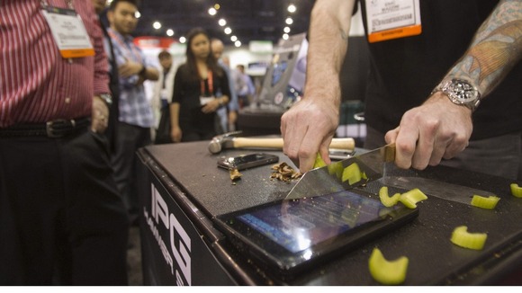 A demonstration of celery being sliced on top of a Kindle protected with an Invisible Phone Guard (IPG) at the CES